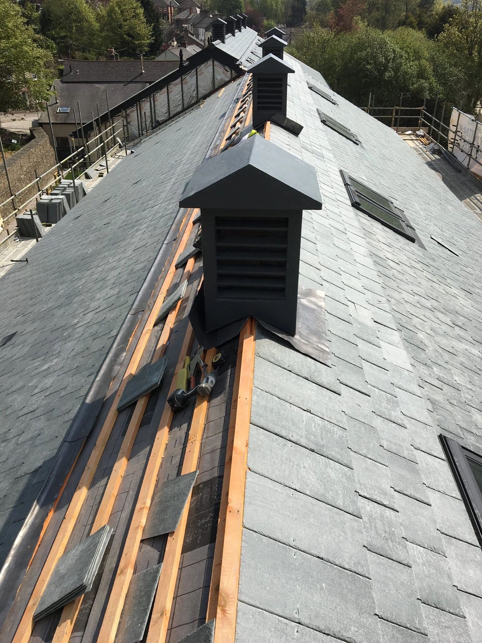 Large commercial building undergoing slate reroofing with scaffolding